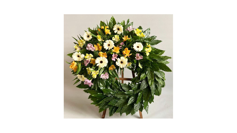 Corona de flores compuesta por alstroemeria, aralia, gerbera, helecho chico, paniculata